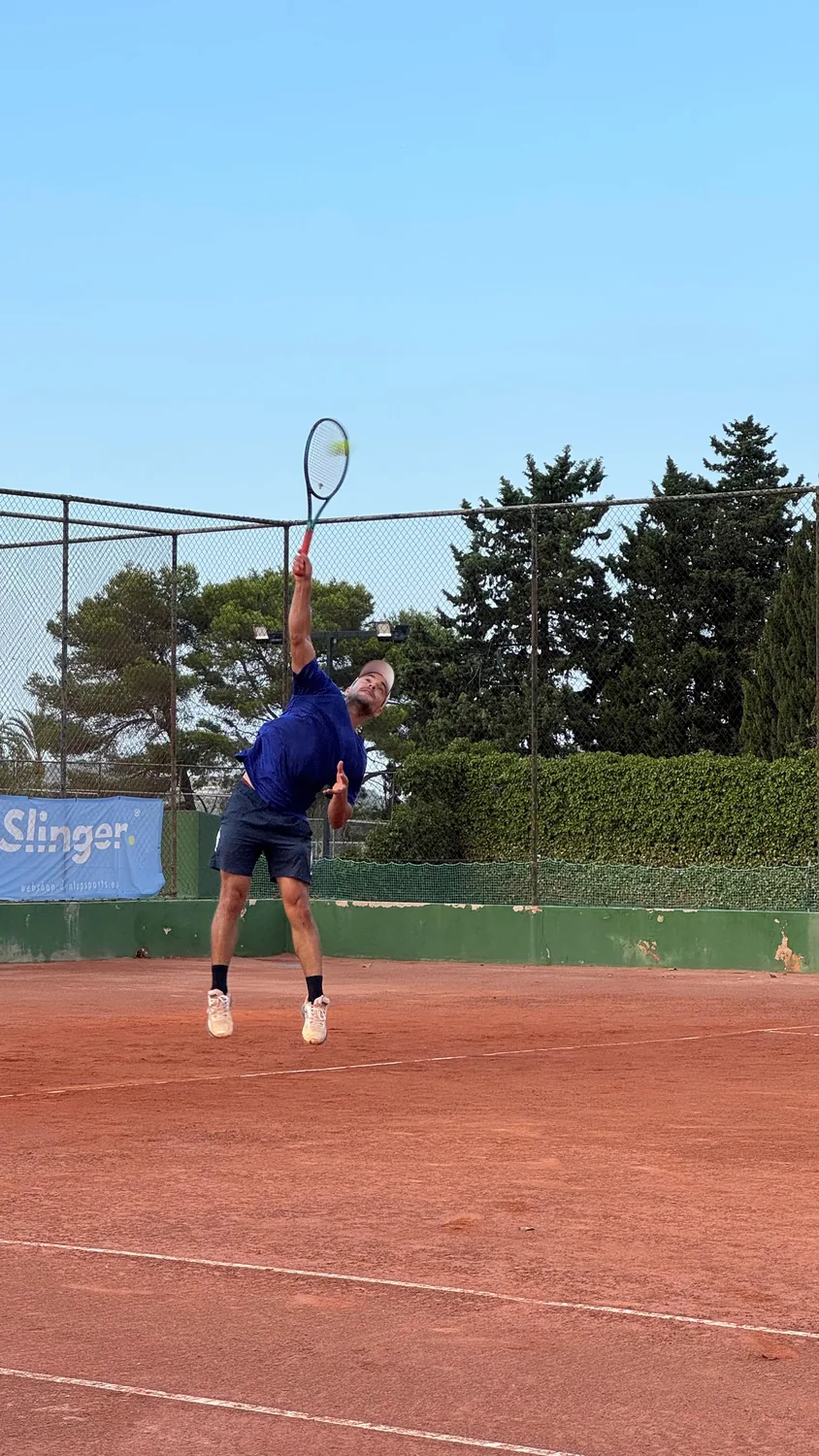 Tennis player serving on a Mallorca clay court
